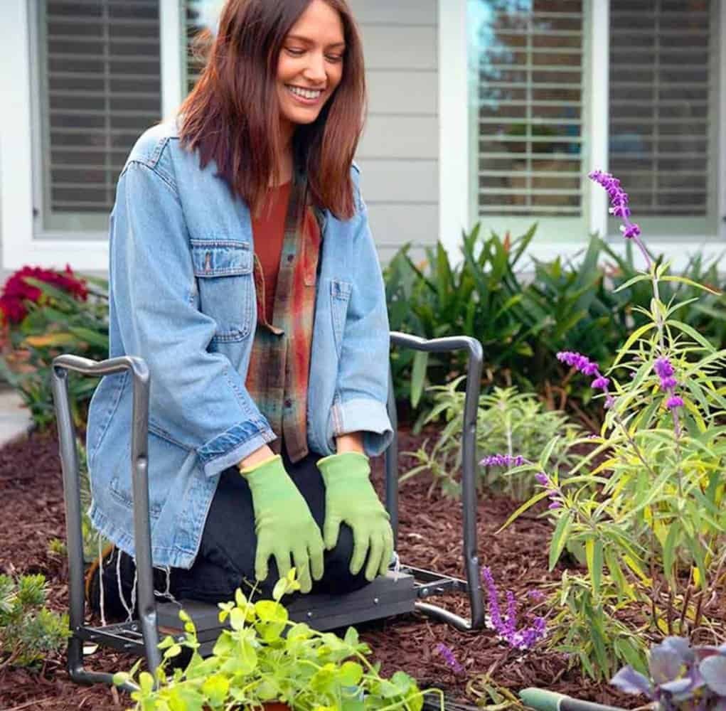 a woman sitting in a garden on arden kneeler